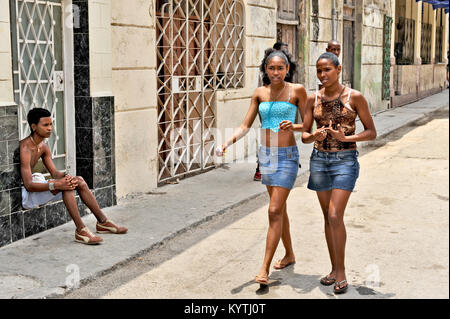 La HAVANE, CUBA, le 7 mai 2009. Deux belles jeunes femmes marchant dans une rue de La Havane, Cuba, le 7 mai 2009. Un garçon assis et regarder. Banque D'Images