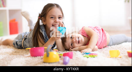 Funny Cute filles enfants jouant avec des jouets de la vaisselle à la maison Banque D'Images