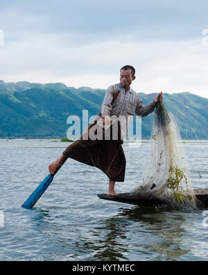 NYAUNGSHWE, MYANMAR - 9 juin 2014 : Leg-paddling tandis que la pêche est une compétence de pêcheur traditionnel dans le lac Inle, Myanmar. Banque D'Images