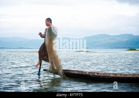 NYAUNGSHWE, MYANMAR - 9 juin 2014 : Leg-paddling tandis que la pêche est une compétence de pêcheur traditionnel dans le lac Inle, Myanmar. Banque D'Images