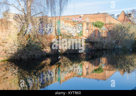 Street art et graffiti peint sur un mur de briques se reflète sur un canal à Digbeth, Birmingham, Royaume-Uni Banque D'Images