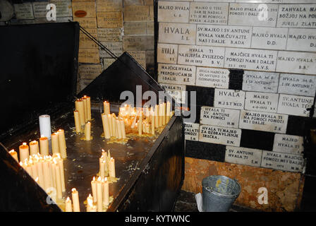 Zagreb, l'établissement Stone Gate (Kamenita Vrata). Ici, c'est la fresque de la Vierge à l'Enfant Jésus et de la statue de Saint Antoine. Sur la photo les murs où sont fixés les ex voto de ceux qui ont reçu une grâce et les bougies. La porte de pierre est l'accès à l'Gornji Grad. Banque D'Images