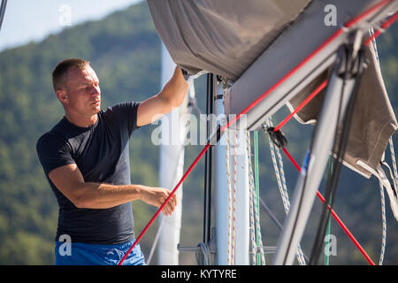 Un jeune marin sur son yacht. Banque D'Images