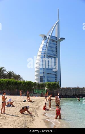 Dubaï, Émirats arabes unis - le 23 novembre 2017 : personnes visitent la plage à Dubaï, Émirats arabes unis. Le bâtiment en arrière-plan est célèbre, l'hôtel Burj Al Arab. Banque D'Images