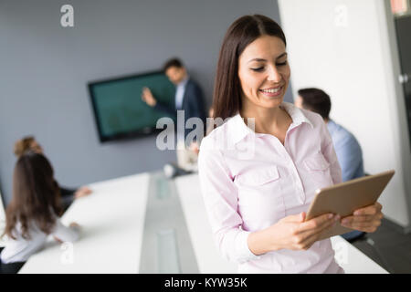 Belle businesswoman holding tablet in office Banque D'Images