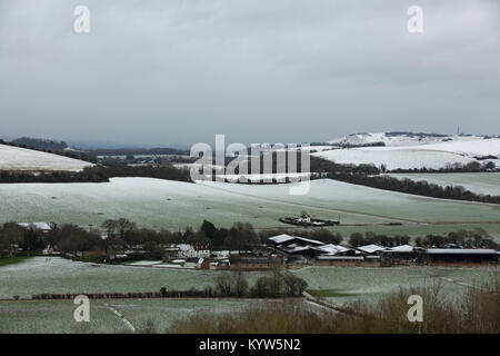 Fine couche de neige sur les South Downs dans le Hampshire. Ciel gris foncé frais généraux qui se profile. Banque D'Images