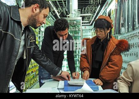 (180117) -- HANGZHOU, le 17 janvier 2018 (Xinhua) -- Vendeur Ma Li (1e R) traite des affaires avec deux commerçants pakistanais à un centre commercial international à Yiwu, l'est de la Chine dans la province du Zhejiang, le 23 décembre 2017. Conformément à Hangzhou, Zhejiang douanes valeur du commerce extérieur s'est élevé à 2,56 billions de yuans (environ 397,6 milliards de dollars américains) en 2017, en hausse de 15,3 pour cent d'année en année. Les exportations et les importations ont augmenté de 10,1 pour cent et 35,6 pour cent sur un an respectivement. (Xinhua/Tan Jin)(mcg) Banque D'Images