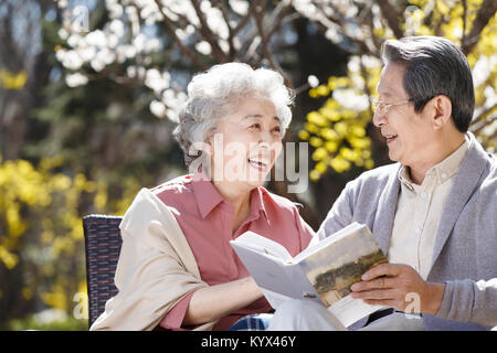 Le vieux couple lire au soleil Banque D'Images