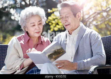 Le vieux couple lire au soleil Banque D'Images