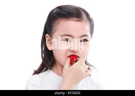 La mignonne petite fille mange les fraises Banque D'Images