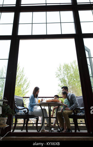 Des familles heureuses prennent un petit déjeuner sur la terrasse Banque D'Images