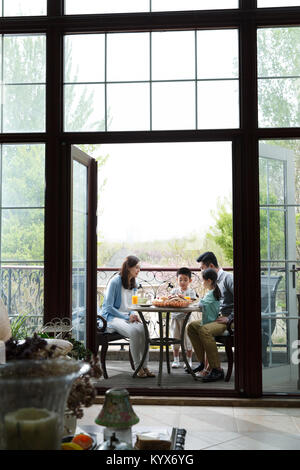 Des familles heureuses prennent un petit déjeuner sur la terrasse Banque D'Images