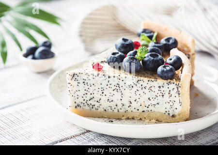 Gâteau au fromage avec poppy et les bleuets sur plaque blanche. Vue rapprochée, tonique libre Banque D'Images