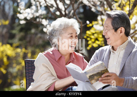 Le vieux couple lire au soleil Banque D'Images