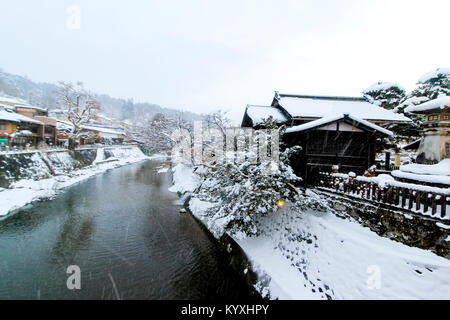 Rivière miyagawa couvrir avec de la neige et à la vue des bâtiments d'époque de red bridge à Takayama vue de style japonais local maison près de pont Nakabashi Banque D'Images