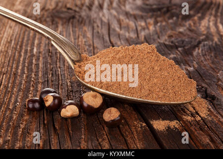 Guarana en poudre dans les graines de guarana avec cuillère sur table en bois. Banque D'Images