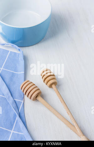 Bol Vide bleu miel en bois cuillères balanciers Tablier de coton blanc sur table. Concept de cuisine pâtisseries de Noël. Noël Pâques. Provence scandinave Kitch Banque D'Images