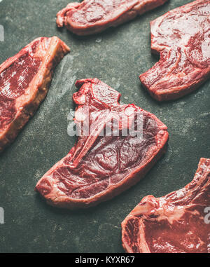 La viande de boeuf cru Raw steak réductions sur fond noir Banque D'Images