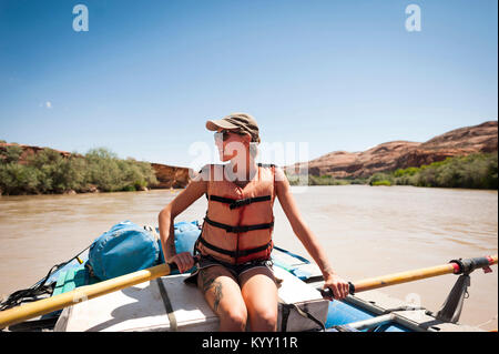 Femme portant un gilet de sauvetage alors qu'il était assis en radeau sur la Rivière San Juan contre ciel clair en été Banque D'Images