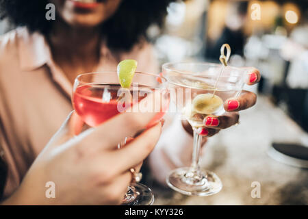 Les mains coupées de businesswomen toasting drinks dans l'hôtel Banque D'Images