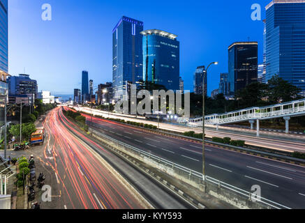 Superbe vue de nuit, le trafic capturé avec une longue exposition, le long de l'autoroute Gatot Subroto au cœur du quartier des affaires de Jakarta au crépuscule dans Banque D'Images