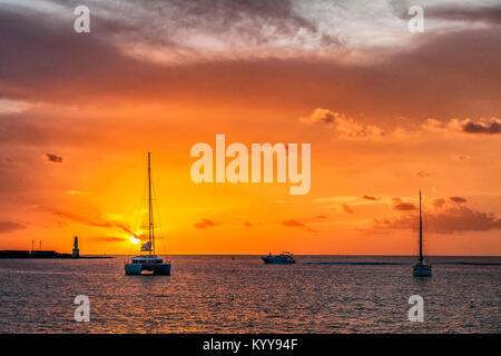 Île des Baléares, Formentera, Espagne. Intense et spectaculaire coucher du soleil avec ses couleurs orange et jaune dans le port de La Savina, à Formentera. Banque D'Images