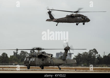 Une paire de Californie Army National Guard hélicoptères Black Hawk UH-60 décoller de Los Alamitos Army Airfield, Los Alamitos, Californie, 9 janvier 2018. Les hélicoptères, avec leur équipage et l'équipement de sauvetage, ont été activés à partir de l'aérodrome de vol à aider le pouvoir civil en réponse à storm-driven coulées dans les zones brûlées par les récents incendies en Californie du Sud. Huit hélicoptères de la Garde nationale de Californie ont été activés dans tout l'état. (U.S. Air National Guard Banque D'Images