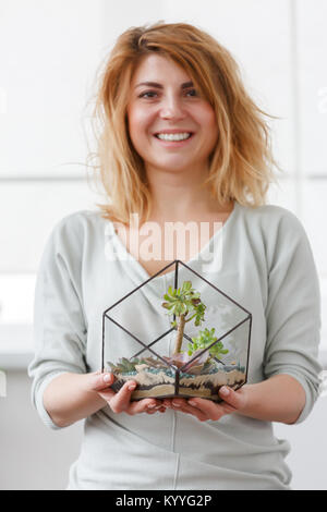Photo d'un fleuriste fille avec florarium avec des pierres et les succulentes Banque D'Images