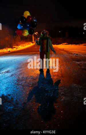 Photo clown avec des boules dans les mains la nuit Banque D'Images