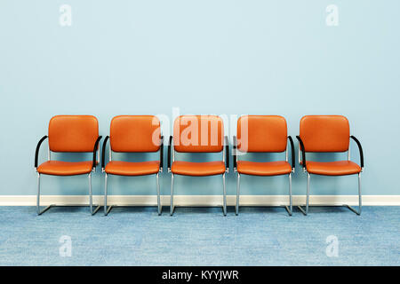 Cinq chaises salle d'attente dans une rangée contre un mur dans une salle vide Banque D'Images