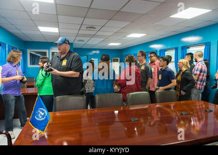 DMZ, Corée - Touristes en bleu salle de conférence de zone commune de sécurité, à Panmunjom, le long de la ligne de démarcation militaire, la Corée du Nord et du Sud Banque D'Images