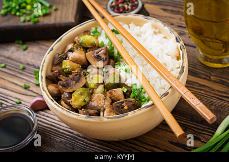 Menu végétalien. Aliments diététiques. Riz bouilli avec les champignons et les choux de Bruxelles dans un style asiatique. Banque D'Images