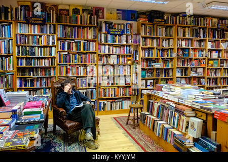 L'intérieur de la librairie - homme lisant un livre à l'intérieur Charlie Byrne's bookshop à Galway, Irlande Banque D'Images