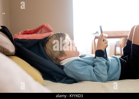 Boy using digital tablet dans la chambre à coucher dans la chambre à coucher Banque D'Images