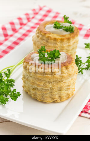 La pâte feuilletée le vol-au-vents rempli de ragoût de champignons, garni de persil frais Banque D'Images