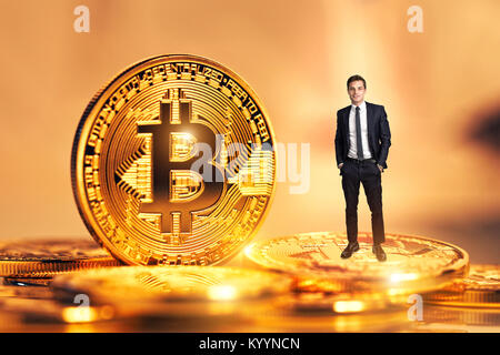 Smiling businessman standing près de golden coins d'argent virtuel concept bitcoin Banque D'Images
