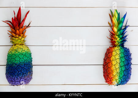 Deux de couleur arc-en-ciel artistique peint formant l'ananas sur du coté de bois blanc avec copie espace central Banque D'Images