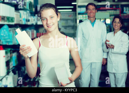 Portrait de jeune fille gaie en pharmacie choisir les produits de soins de santé Banque D'Images