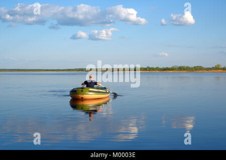 L'homme dans un bateau gonflable flotte sur la rivière, la vue de l'arrière Banque D'Images