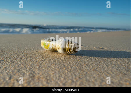 Bouteille en plastique échoué sur une plage déserte, la pollution des océans avec des non-recyclables en plastique. Banque D'Images