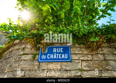 Rue du Chateau panneau routier français avec sun flare en Puligny Montrachet Bourgogne France Banque D'Images