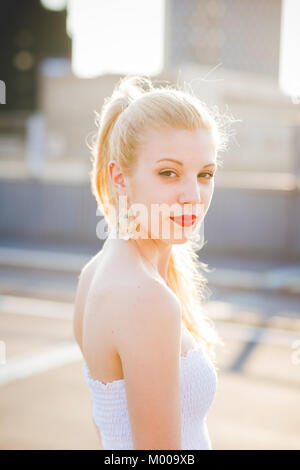 Portrait de jeune femme belle dans la ville lumière arrière à la caméra en souriant - customer, bonheur, concept serein Banque D'Images