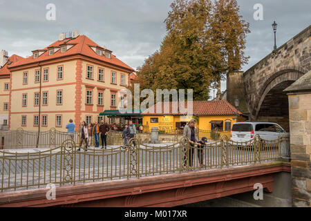 Une femme et un jeune garçon regardent sur un pont qui traverse le Čertovka , un canal d'eau dans le quartier de Lesser, Prague près du café Marnice Banque D'Images