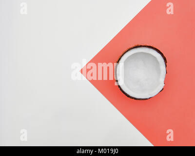 Télévision de coco noix de coco dans la moitié laïcs Peel est située sur deux-ton arrière-plan Vue de dessus colorés à la mode la maquette photo avec espace pour texte Banque D'Images