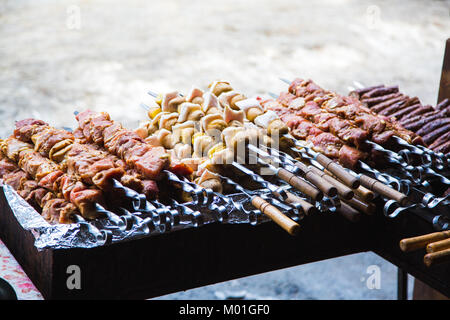 De nombreuses matières premières brochettes de viande de porc et de veau et de pommes de terre crues avec du bacon. Banque D'Images