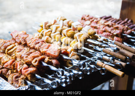 De nombreuses matières premières brochettes de viande de porc et de veau et de pommes de terre crues avec du bacon. Banque D'Images