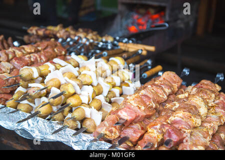 De nombreuses matières premières brochettes de viande de porc et de veau et de pommes de terre crues avec du bacon. Banque D'Images