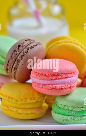 Délicieux macarons colorés sur la plaque et le lait Banque D'Images