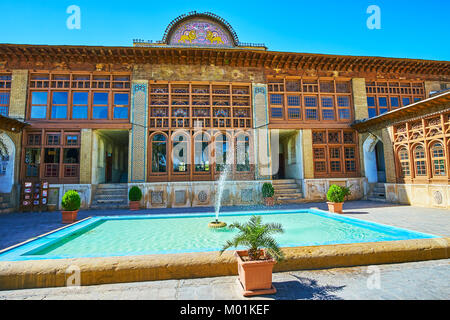 SHIRAZ, IRAN - 12 octobre 2017 : Le bâtiment principal de Zinat Ol-Molk complexe avec sol carrelé sur fronton, de nombreux détails en bois et en pierre carvin Banque D'Images