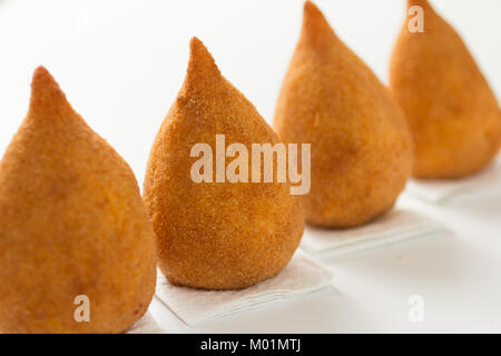 Des bouchées de poulet frit appelé Coxinha au Brésil. Les Brésiliens mangent comme alternative à la restauration rapide ou des parties. Trois collations sur une ligne sur l'onglet blanc Banque D'Images